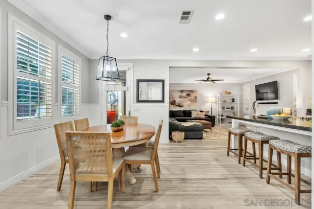 a dining room with furniture a chandelier and wooden floor