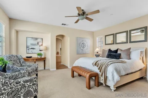 a spacious bedroom with a bed a couch and a window