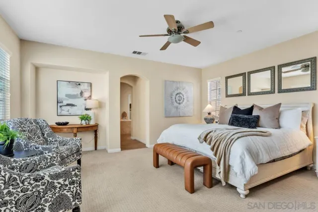 a spacious bedroom with a bed a couch and a window