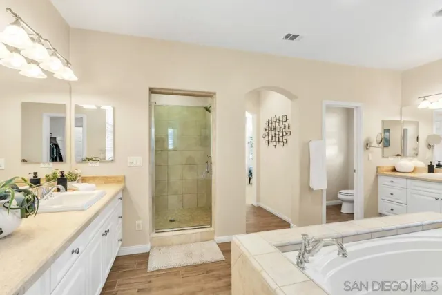 a spacious bathroom with a granite countertop sink mirror and shower