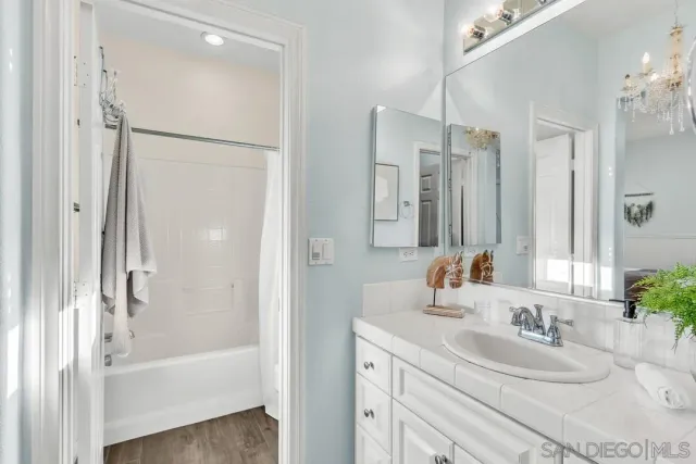 a bathroom with a tub sink a mirror and shower