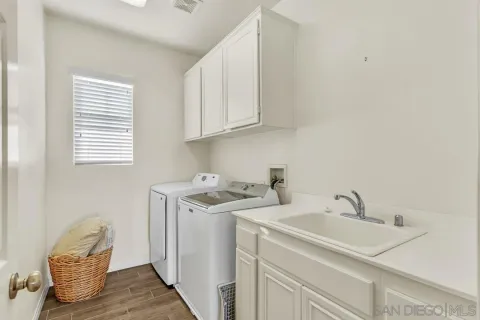 a utility room with sink dryer and washer