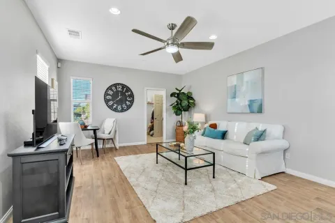 a living room with furniture a clock on wall and a window