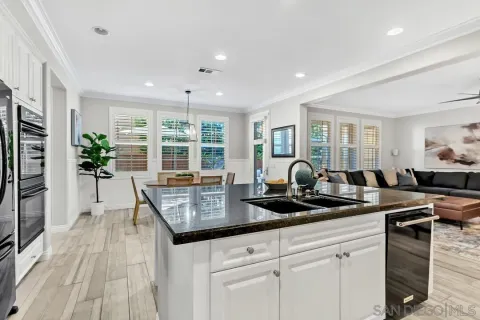 a kitchen with granite countertop a stove and white cabinets