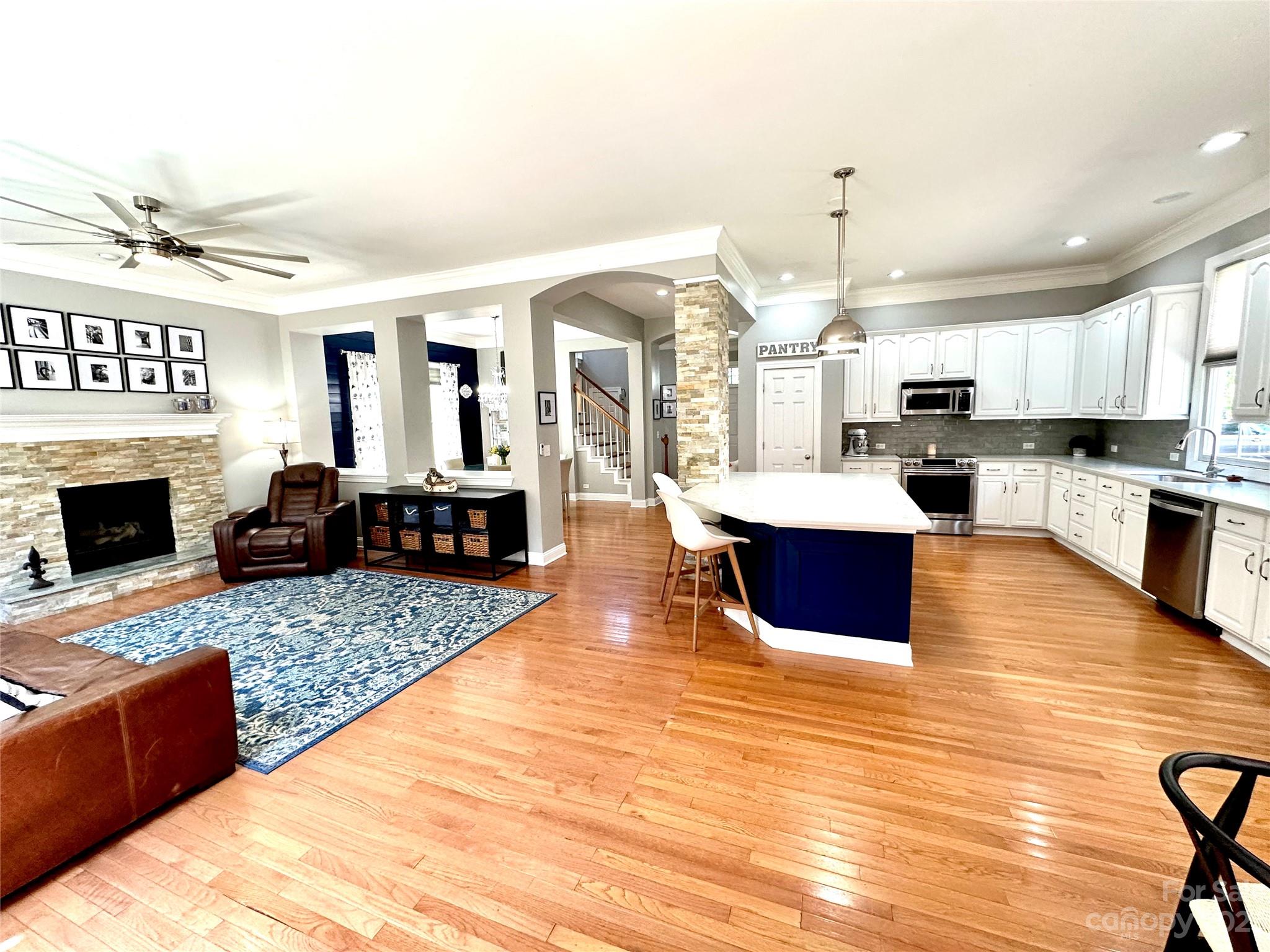 7112 Michael Scott Crossing Fort Mill, SC 29708 - Photo 14 of 48 a large living room with stainless steel appliances granite countertop a stove top oven a fireplace a flat screen tv and a fireplace