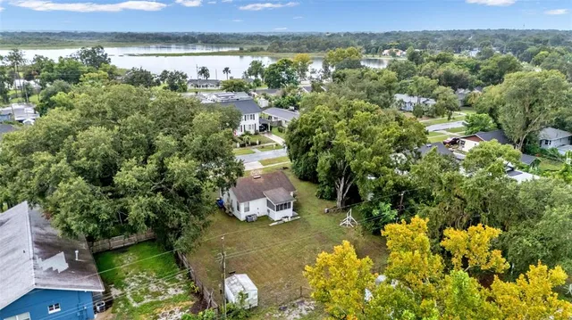 an aerial view of a house with a yard and lake view