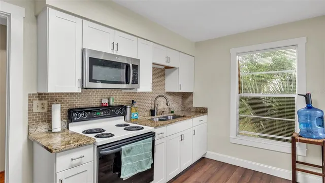 a kitchen with stainless steel appliances a stove sink microwave and cabinets