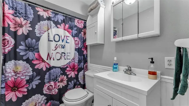 a bathroom with a sink toilet and mirror