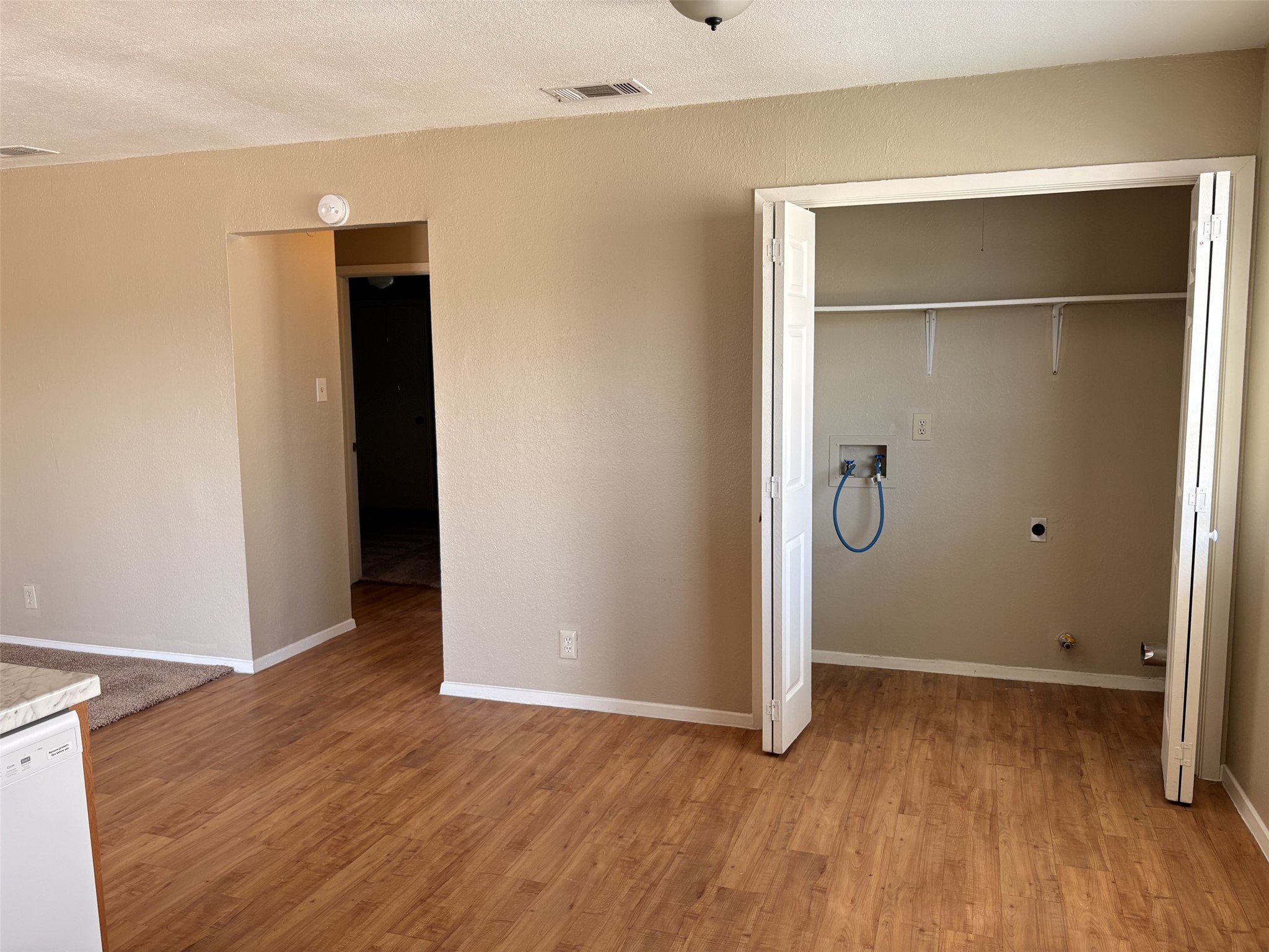 9902 Roxanna Drive, Unit D Austin, TX 78748 - Photo 3 of 19 Dining Room and Laundry closet featuring washer hookup, light wood-style floors, hookup for an electric dryer, a textured ceiling, and gas dryer hookup
