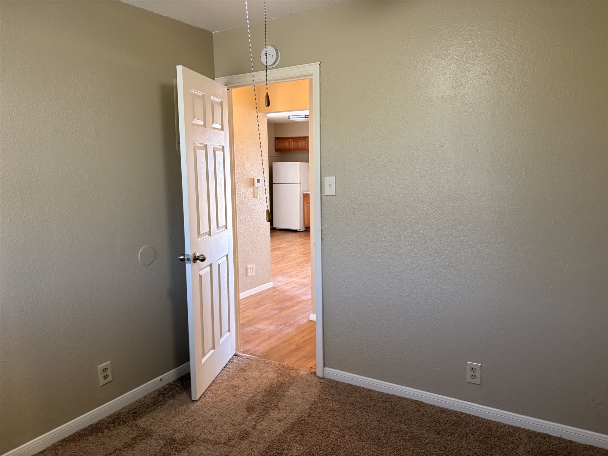 9902 Roxanna Drive, Unit D Austin, TX 78748 - Photo 5 of 19 Unfurnished bedroom with light colored carpet and a textured wall