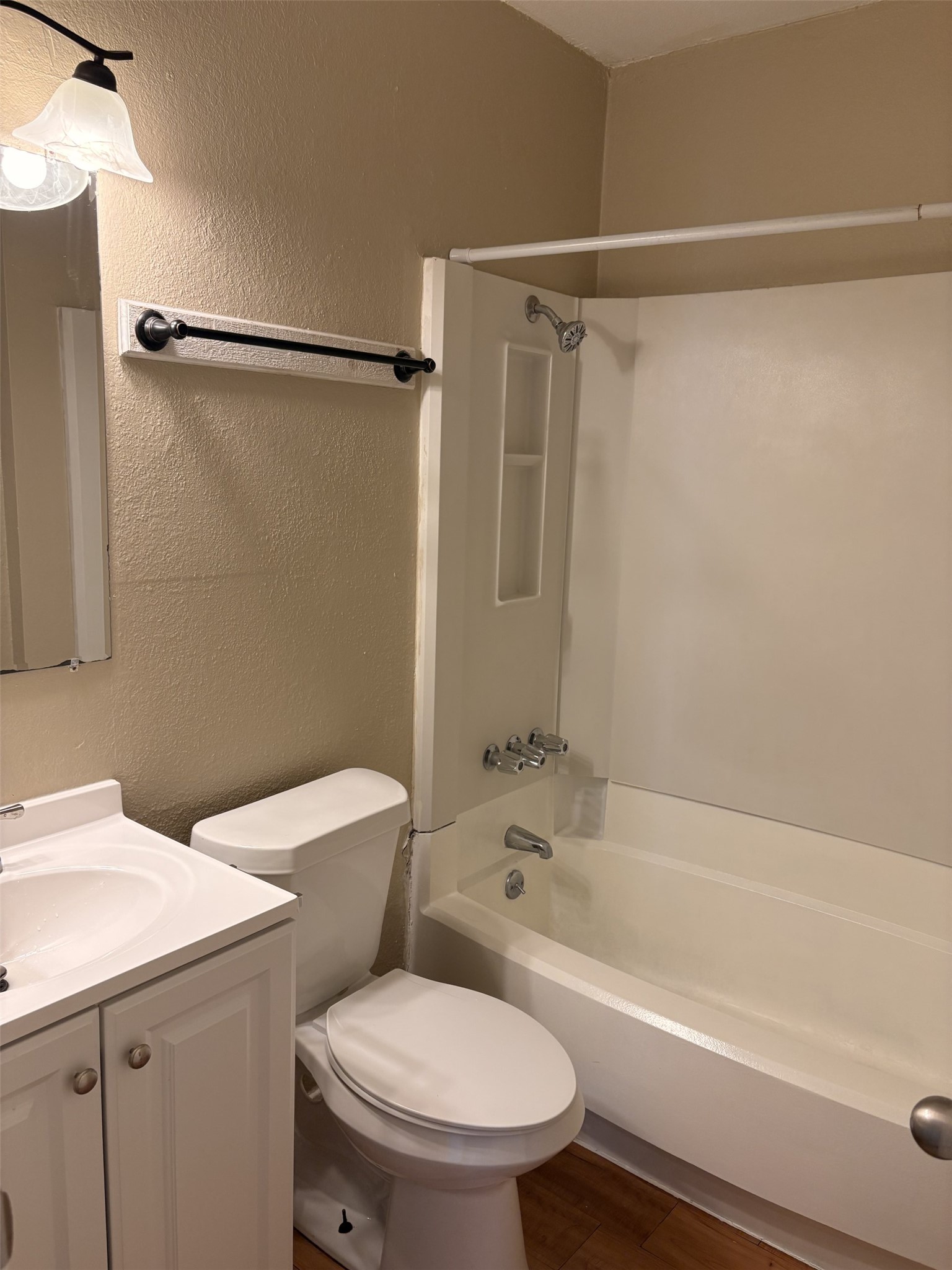 9902 Roxanna Drive, Unit D Austin, TX 78748 - Photo 7 of 19 Bathroom with a textured wall, vanity, shower combination, and dark wood-style floors