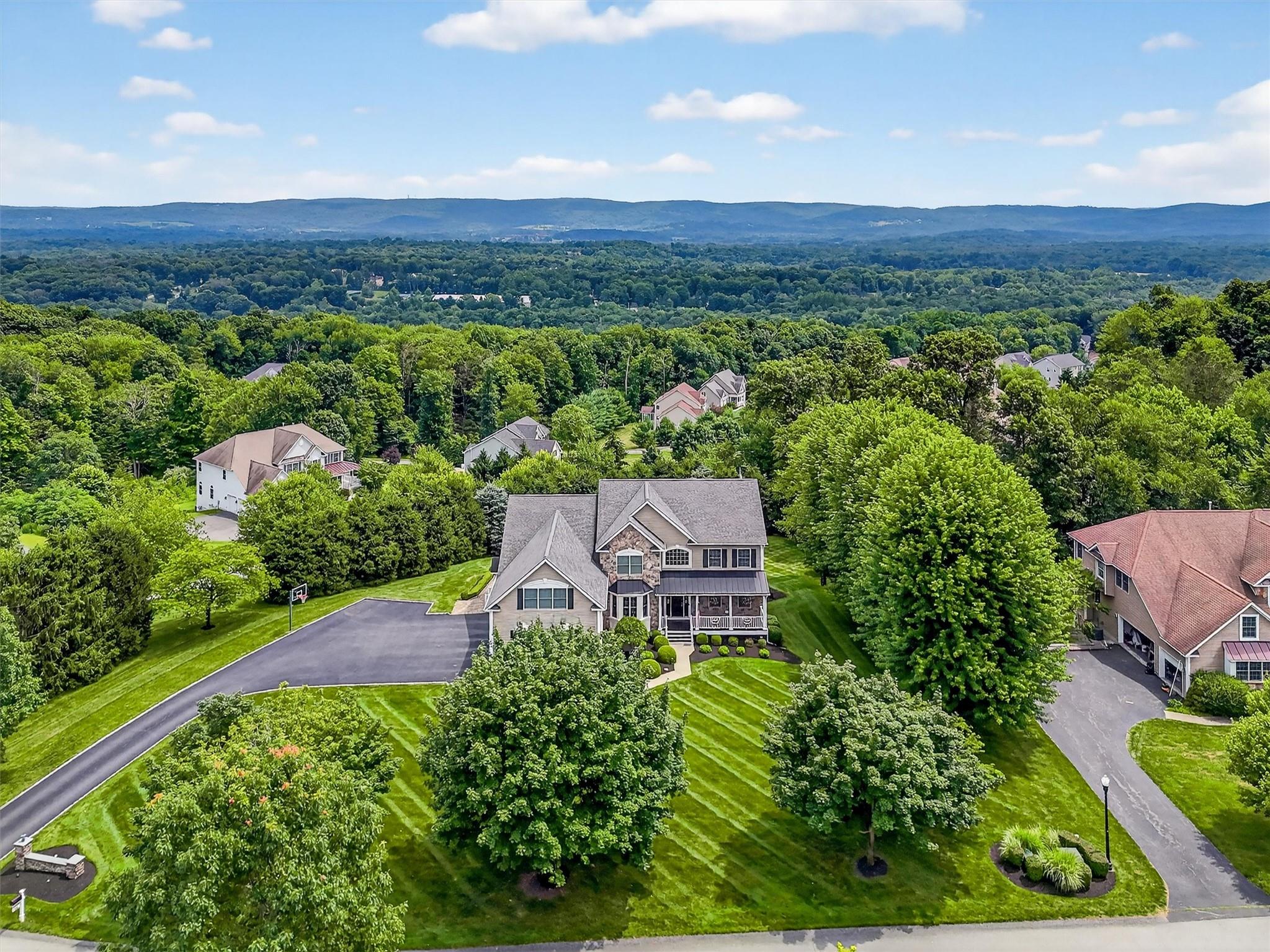 Welcome to your FOREVER home Perched atop the highest point in the prestigious Legends neighborhood, just 65 miles from Manhattan, this magnificent custom Colonial is truly the crown jewel of the community. Set on a glorious 1.16-acre corner lot, the property offers unparalleled privacy, sweeping views of the Hudson Valley, and an elevated lifestyle in one of the area’s most sought-after locations. Tree-lined streets frame this stunning residence, while the manicured grounds, mature landscaping, and expansive driveway create exceptional curb appeal. This is more than just a home—it’s a private retreat that blends luxury, function, and serenity with postcard-perfect views in every direction. Welcome to your forever home in The Legends.