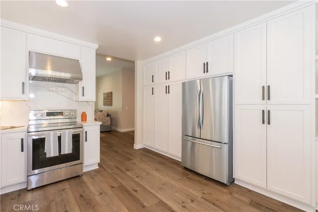 a kitchen with stainless steel appliances a refrigerator and a stove top oven