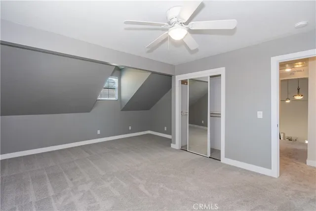an empty room with a ceiling fan and a view of bathroom