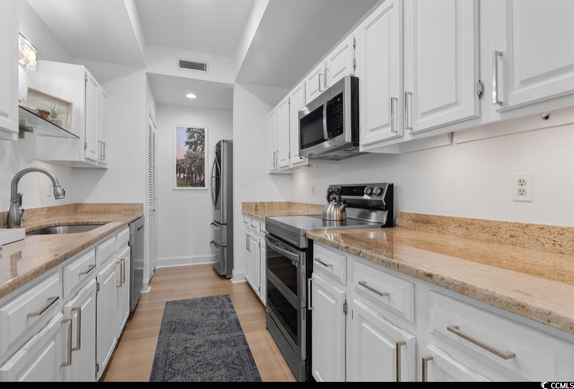 1970 Governors Landing Road, Unit 201 Murrells Inlet, SC 29576 - Photo 13 of 25 Kitchen with appliances with stainless steel finishes, light wood-type flooring, white cabinetry, light stone countertops, and recessed lighting