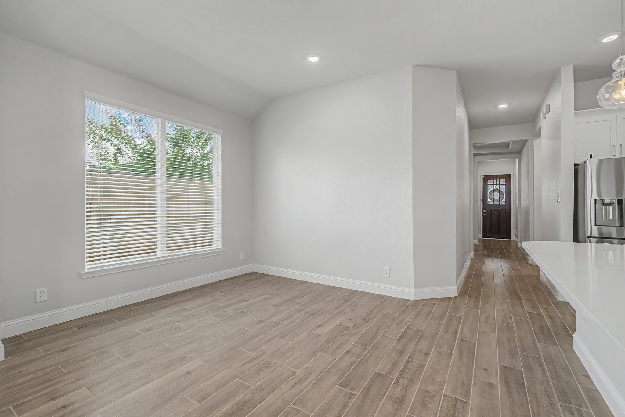 21339 Sierra Point Lane Porter, TX 77365 - Photo 10 of 36 Bright and open dining area with wood-look tile flooring, large windows allowing natural light, and a modern kitchen area with stainless steel appliances.