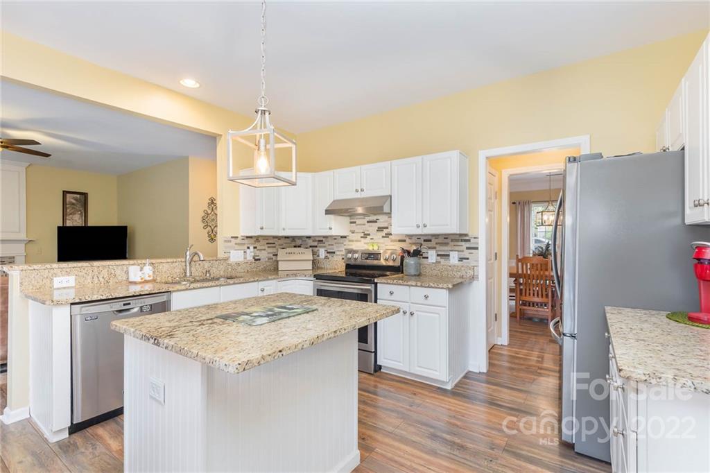 154 Coronilla Road Mooresville, NC 28117 - Photo 11 of 38 a kitchen with stainless steel appliances granite countertop a stove top oven a sink dishwasher and a refrigerator with wooden floor