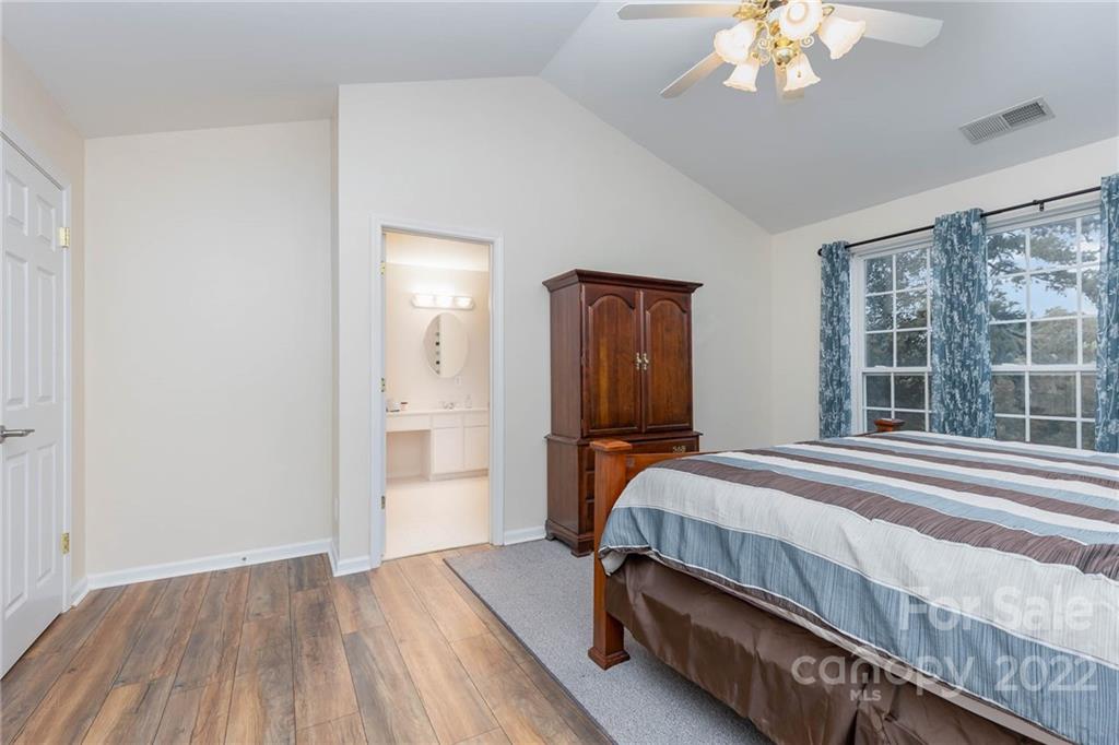 154 Coronilla Road Mooresville, NC 28117 - Photo 21 of 38 a bedroom with a bed and a chandelier