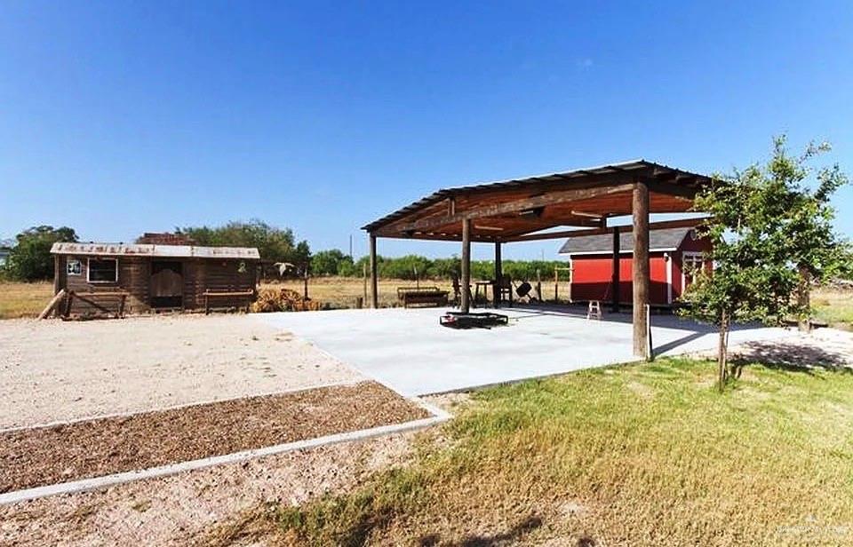 3921 Los Ebanos Road Mission, TX 78573 - Photo 2 of 5 a view of a swimming pool with a chair and tables in the patio