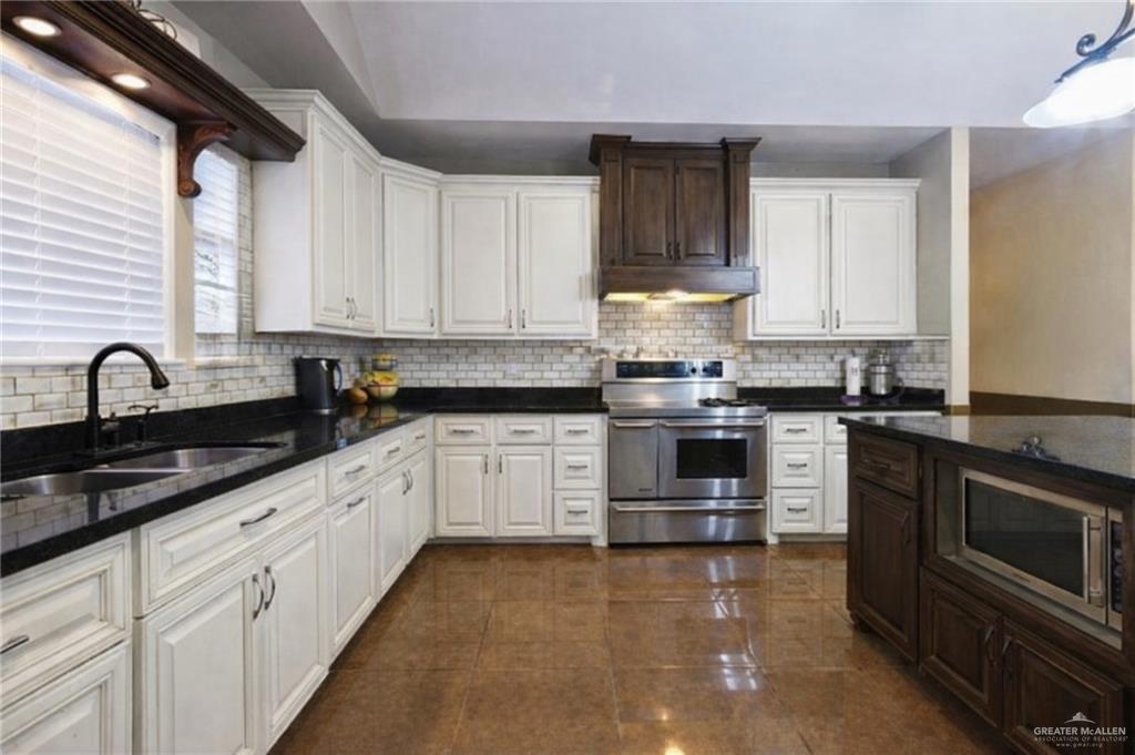 3921 Los Ebanos Road Mission, TX 78573 - Photo 4 of 5 a kitchen with granite countertop white cabinets and stainless steel appliances