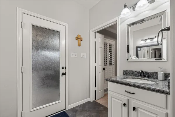 a bathroom with a granite countertop sink a mirror and a shower
