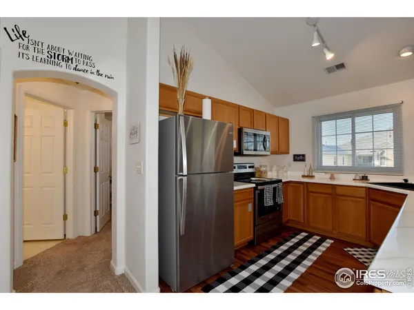 a kitchen with stainless steel appliances granite countertop a refrigerator a stove and a sink