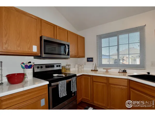 a kitchen with a sink a stove cabinets and a window