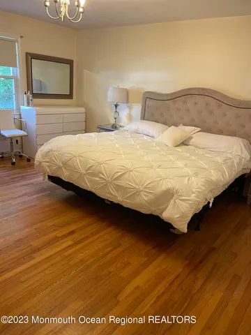 a bedroom with a bed and wooden floor