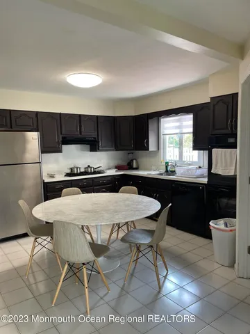 a kitchen with a sink a stove a refrigerator and chairs