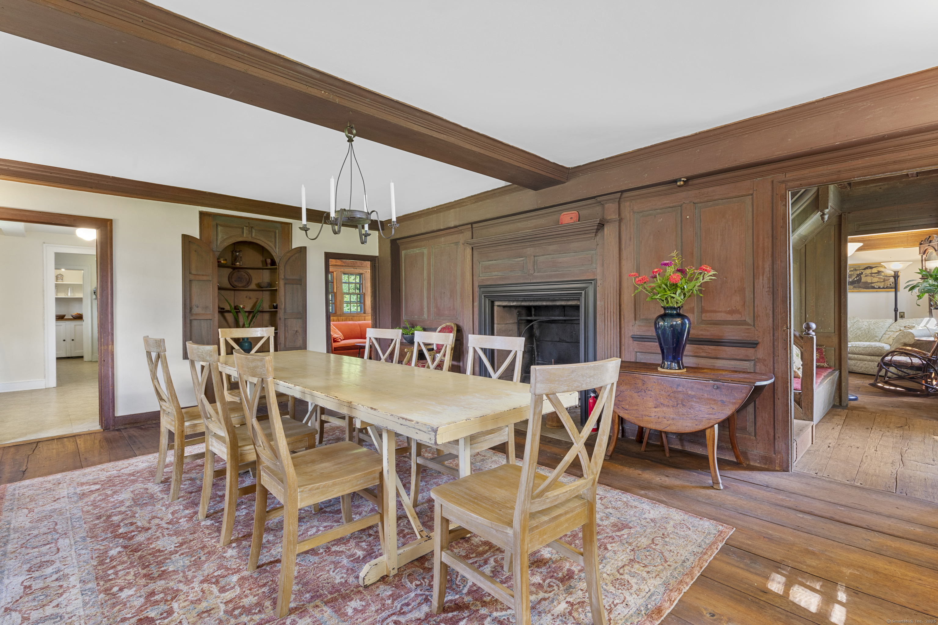 90 Duck Hole Road Guilford, CT 06437 - Photo 18 of 38 a dining room with furniture wooden floor a rug a potted plant and a chandelier
