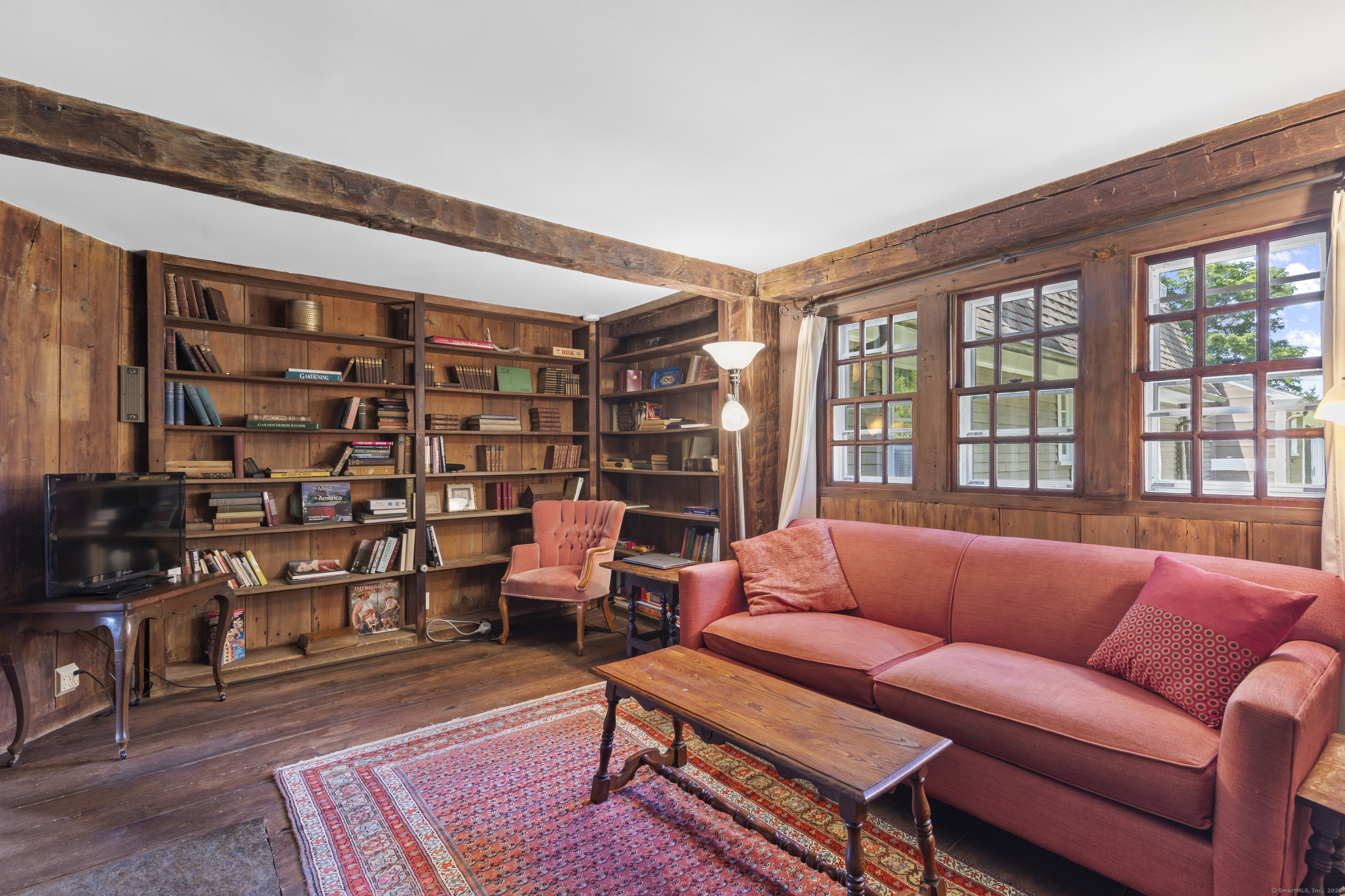 90 Duck Hole Road Guilford, CT 06437 - Photo 21 of 38 a living room with furniture a ceiling fan and a book shelf