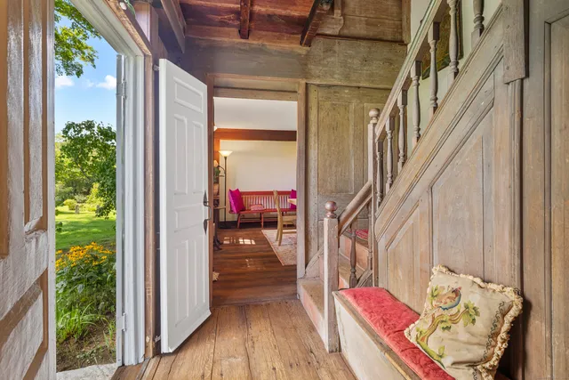 a dining room with furniture wooden floor a rug a potted plant and a chandelier