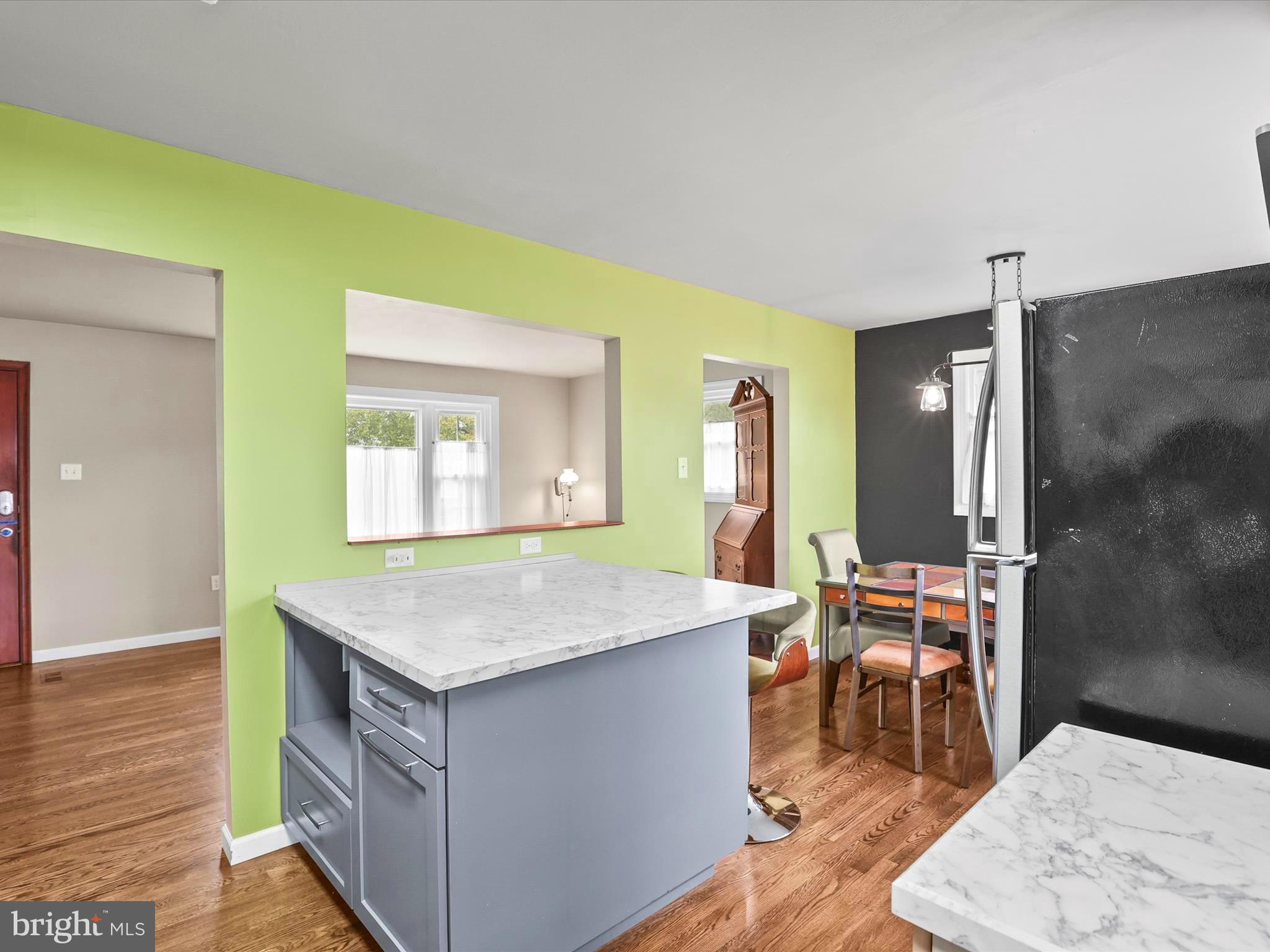 1316 Livingstone Road York, PA 17404 - Photo 19 of 33 a room with kitchen island a sink dishwasher a dining table and chairs with wooden floor
