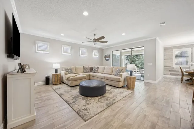 a living room with furniture kitchen view and a large window