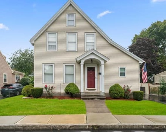 a view of a white house with a yard and plants