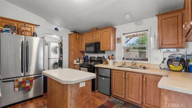 a kitchen with stainless steel appliances a stove a sink a refrigerator a window and cabinets