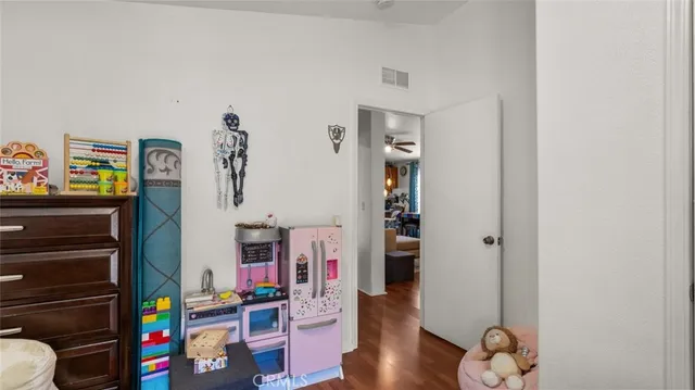 a view of play room with toys and wooden floor