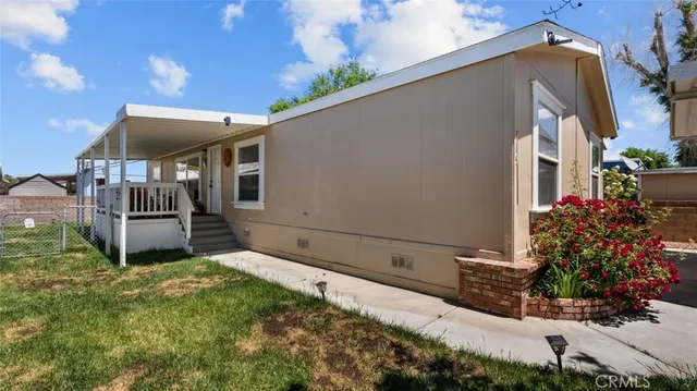 a view of a house with a small yard and flower plants