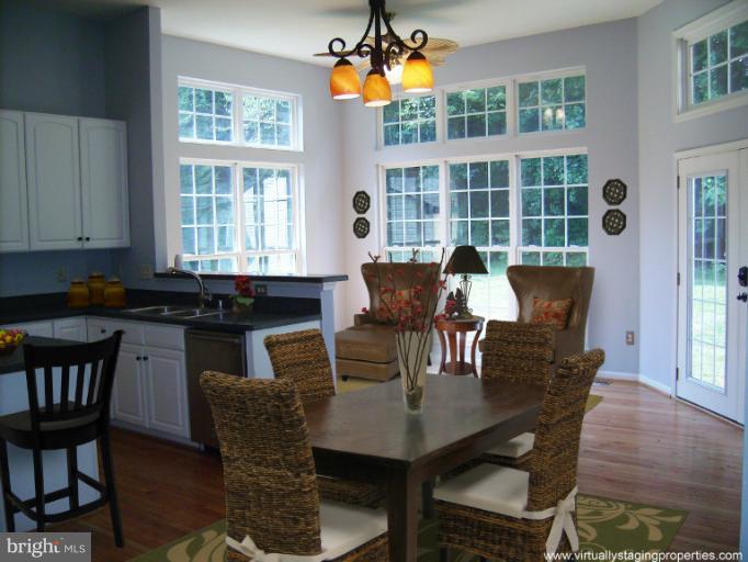 9319 Old Court Road Baltimore, MD 21244 - Photo 6 of 23 a dining room with furniture potted plants and wooden floor