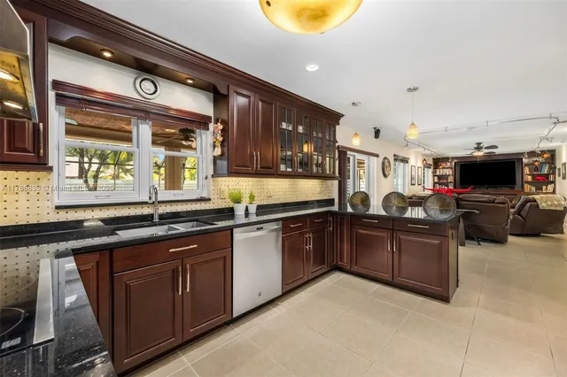 a kitchen with stainless steel appliances granite countertop a sink and cabinets