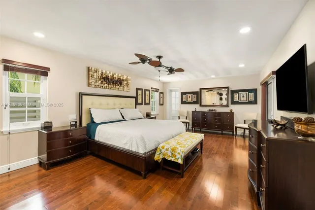 a spacious bedroom with a bed window and a flat screen television