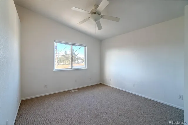 an empty room with a window and a ceiling fan