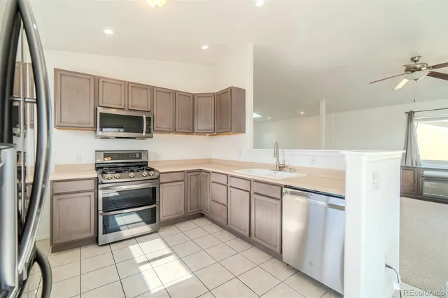 a kitchen with stainless steel appliances a refrigerator and a stove top oven