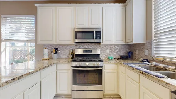 a kitchen with granite countertop white cabinets and white appliances