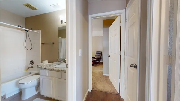 a bathroom with a granite countertop sink toilet and shower