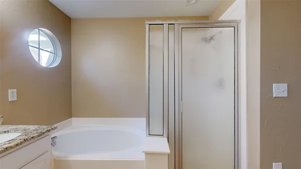 a bathroom with a granite countertop bathtub and a sink