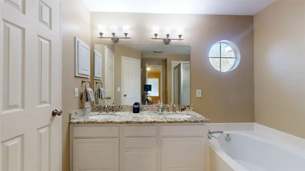 a bathroom with a granite countertop sink mirror and a bathtub