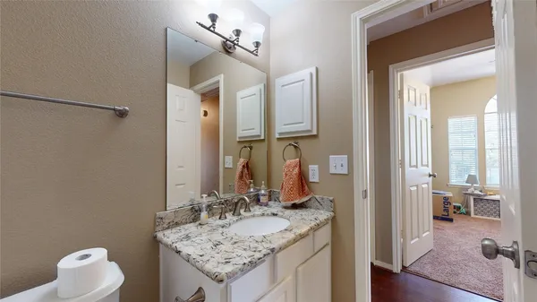 a bathroom with a granite countertop sink and a mirror