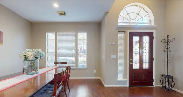 a dining room with furniture potted plants and wooden floor
