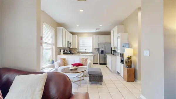 a living room with stainless steel appliances furniture and a window